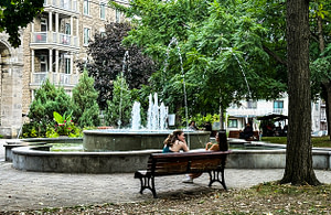 Laurier Avenue was one of my favorite walks. I attended a weekly writers’ group at Mordecai-Richler Library and enjoyed strolling the avenue to catch the Metro at Laurier Station. 
One afternoon, I spotted a large group of teenagers armed with cameras. They were photographing Lahaie Park from every conceivable angle. Their leader explained a local school sponsors summer activities for teens and this was photography week.
With the joyous chaos of teens all around, two women enjoyed leisure time together.