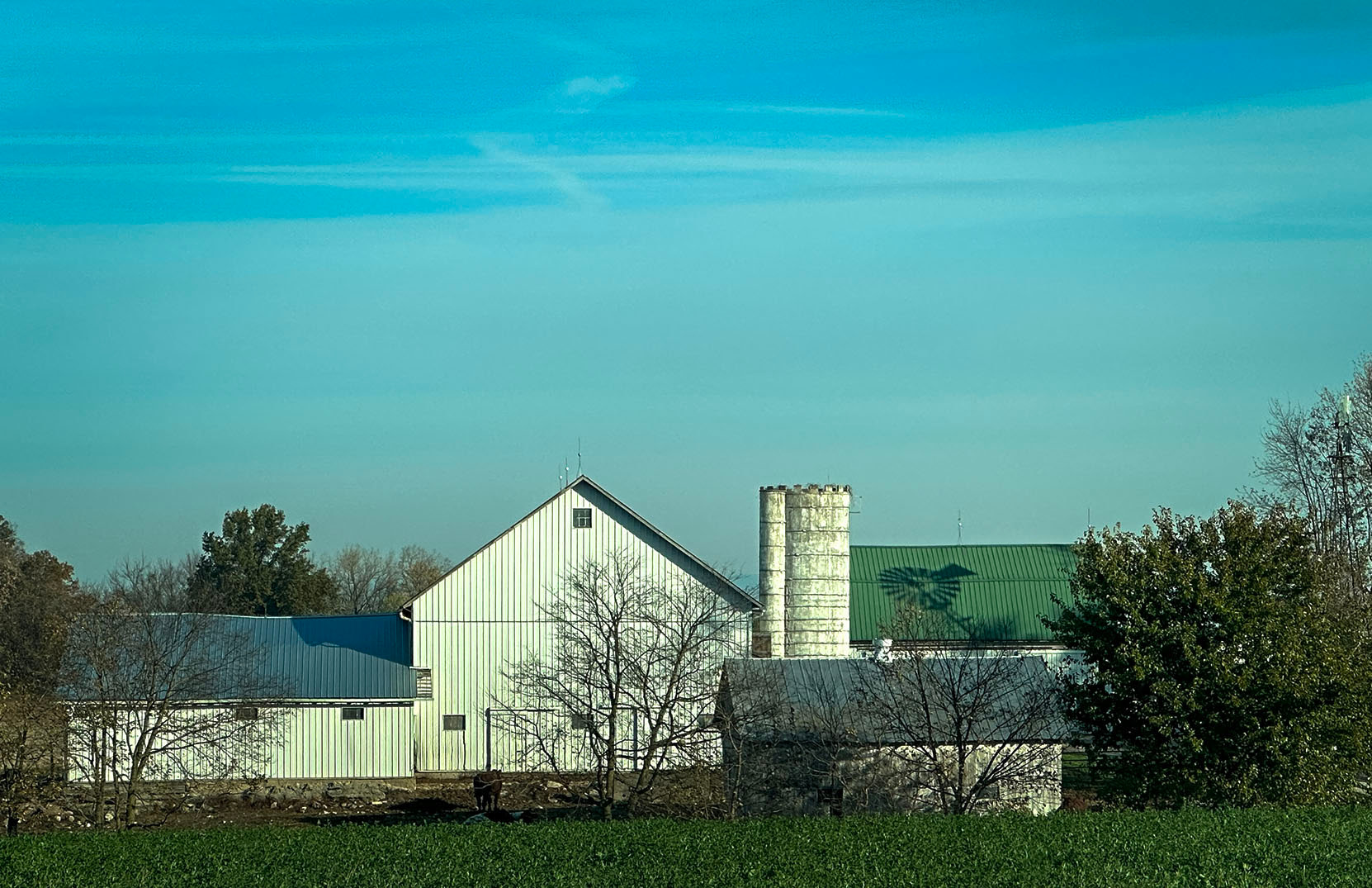 A barn in Fort Wayne Indiana with a windmill Shadow on it.